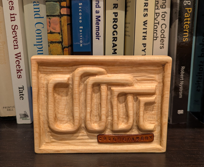 CodeRefinery logo as a hand-carved wooden stand